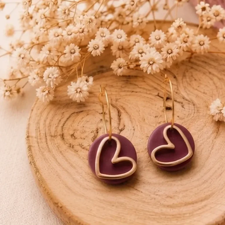 Bordeauxrote Herz-Ohrringe aus Polymer Clay auf einer Holzscheibe