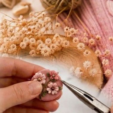 Ohrring mit Blüten wird von Hand mit einer Zange gefertigt